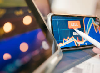 Profissional de negociação em múltiplos mercados examinando Bitcoin, Ethereum e operações de câmbio